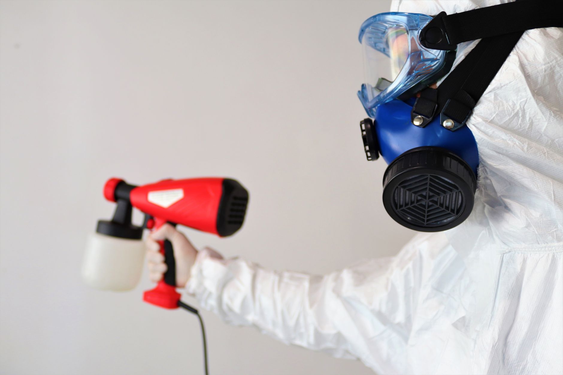 A mold remediation technician carefully removing mold-damaged drywall in a Cedar Hill residential bathroom, with proper containment barriers visible.